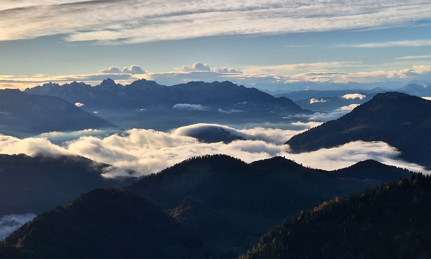 Blick von den Chiemgauer Bergen in das wolkenverhangene Tal